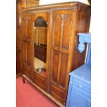 An early 20th century moulded oak single mirror door wardrobe, raised on squat base with square