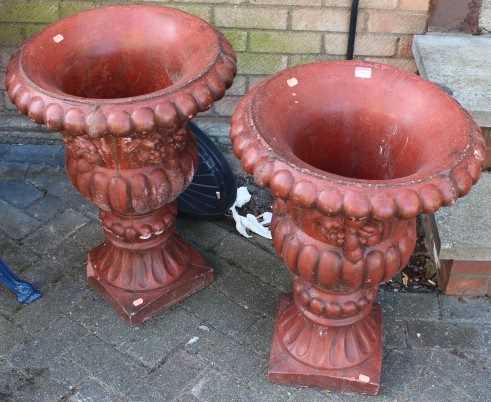 A pair of painted reconstituted garden urns, each of reeded form with floral and fruit decoration (