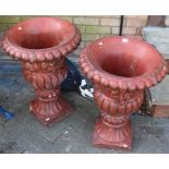 A pair of painted reconstituted garden urns, each of reeded form with floral and fruit decoration (