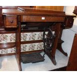 An early 20th century Singer treadle sewing machine, housed within hinged compartment, w.86cm