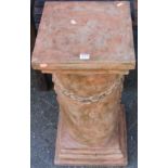A painted terracotta square stepped garden pedestal, having circular column with chain link