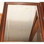 A reproduction faux mahogany framed and bevelled wall mirror, 102 x 74cm