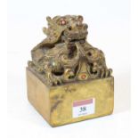 A modern Chinese gilt bronze desk seal, surmounted by a dragon, inset with coral and turquoise, h.