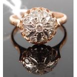 A yellow metal diamond set cluster ring, the illusion flower setting set with nine round cuts,