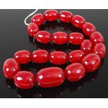 A beaded faux cherry amber necklace, the largest bead w.4cm, gross weight 211g, 58cm