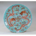 A Chinese stoneware charger, on a turquoise ground, enamel decorated with two five-claw dragons