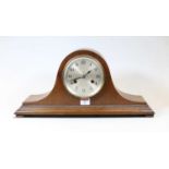 A 1930s oak cased mantel clock, having a silvered dial with Arabic numerals and eight day movement