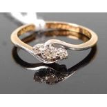 An 18ct gold and platinum diamond three stone ring, the small round cuts in a crossover setting, 2g,