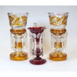 A pair of Bohemian style amber overlaid etched and cut glass table lustres, each with glass prism