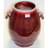 A large Chinese red flambe glazed stoneware vase, of pear shape having twin antelope handles with