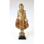A carved softwood and gilt painted religious figure, in standing pose on a plinth base, h.49cm