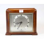 An Elliott mahogany cased mantel clock, having a square silvered dial with Roman numerals, signed