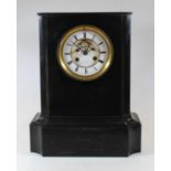 A large late 19th century black slate mantel clock, having a enamelled chapter ring, with Roman