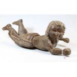 A chip-carved pine figure of a child in crawling pose, length 56cm