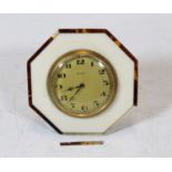 An early 20th century ivory and tortoiseshell mounted travel clock having a circular dial with