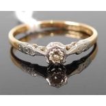 An 18ct gold diamond solitaire ring, the round cut diamond being in a white metal illusion crown