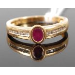 An 18ct gold, ruby and diamond point set dress ring, the oval cut ruby flanked to either side with