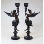 A pair of bronze candlesticks, each in the form of a Melusina and mounted on a circular polished