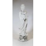 A large Chinese blanc de chine figure of Guanyin, shown in standing pose on a floral encrusted