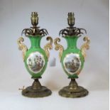 A pair of early 20th century porcelain and brass mounted table lamps, each decorated with ruins in a