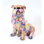 A modern composition model of a bulldog shown in seated pose, colourfully decorated with flowers,