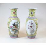 A pair of 20th century Chinese famille jaune vases, enamel decorated with birds amongst flowers,