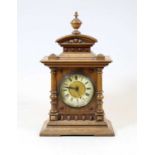 An early 20th century German walnut cased mantel clock, the enamel chapter ring showing Roman