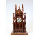 A 20th century fret-carved mahogany quartz Cathedral clock, of architectural form, with crocket