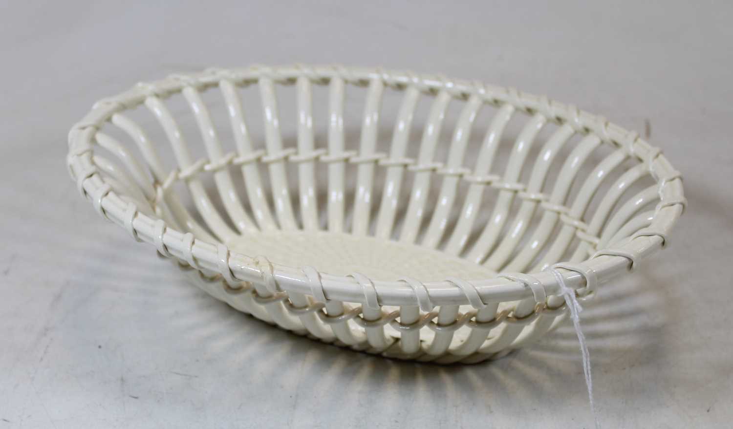 A 19th century cream ware basket with ropetwist border and impressed weave centre, beehive mark to