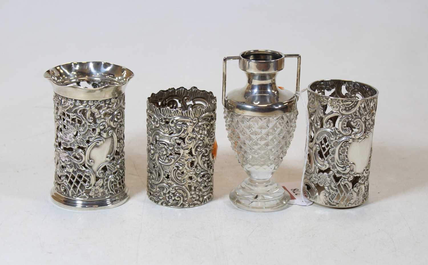 A circa 1900 silver sleeve having a shaped rim, the cylindrical body with floral and C-scroll