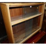 A 1970s light oak low bookcase with four glazed sliding doors, width 92cm