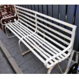 A 19th century slatted wrought iron four-seater garden bench, raised on pronounced strapwork