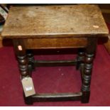 A 17th century style joined oak joint stool, the top with exposed nail heads, raised on bobbin