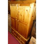 A modern pine double door wardrobe, having four short lower drawers, w.123cm