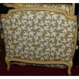 A late 19th century French painted and upholstered single bedstead, having twin footed side rails,