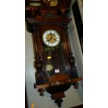 An early 20th century walnut Vienna droptrunk wall clock, with pendulum and keys