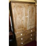 A Victorian pine linen cupboard, having twin recessed panelled arched upper doors enclosing