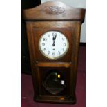 A 1920s oak droptrunk wall clock, h.75cm