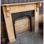 A pine fire surround with serpentine top, together with black painted cast iron fire place(2)