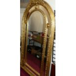 A large contemporary French style gilded and floral composite decorated arched floor mirror, the oak