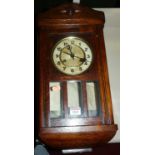 A 1930s oak droptrunk wall clock, with pendulum and key