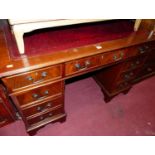 A reproduction mahogany and gilt tooled burgundy leather inset twin pedestal writing desk, width