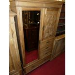 A late Victorian limed oak compactum wardrobe, having single mirrored door, single relief carved