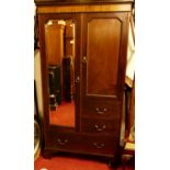 An early 20th century mahogany compactum wardrobe, having single long mirrored door, single panelled