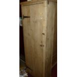 A rustic pine single door pantry cupboard, enclosing fixed shelved interior with iron strapwork