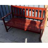 A stained wood and slatted two-seater garden bench, width 122cm