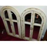 A pair of contemporary French style cream painted arched wall mirrors, each in the form of window