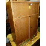 A 1970s light oak student's bureau, with fall front compartment over twin lower cupboard doors,