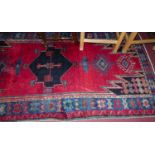 A Turkish woollen red ground rug, having floral geometric ground within tramline borders, 267 x