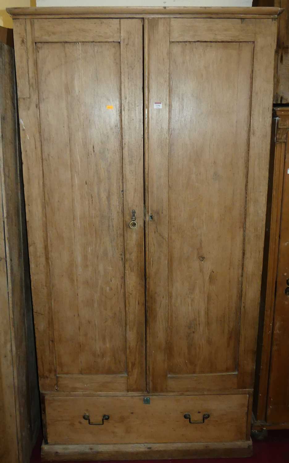 A pine double door wardrobe, enclosing a hanging rail over single long lower drawer, width 106cm